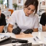 Docente e allieve durante una simulazione di dermopigmentazione su supporto in silicone